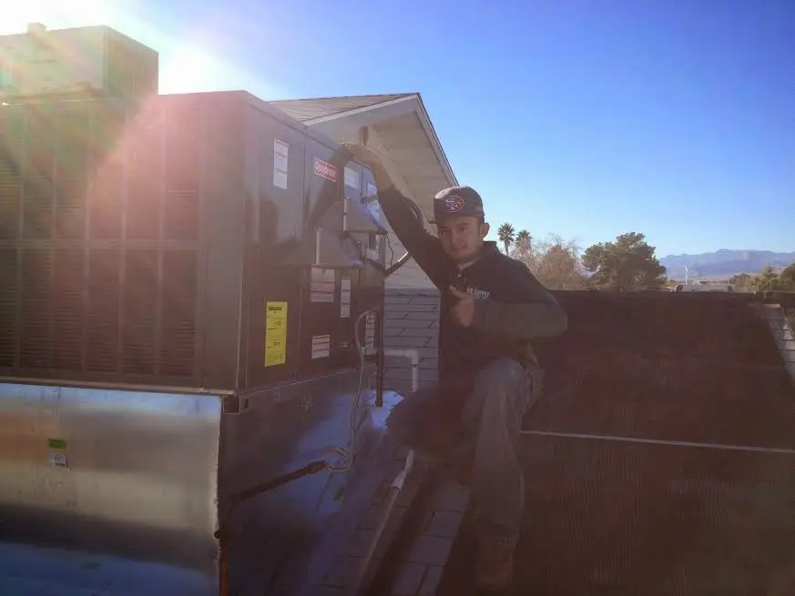 HVAC technician performing AC Tune-Up on a rooftop unit in North Ridgeville